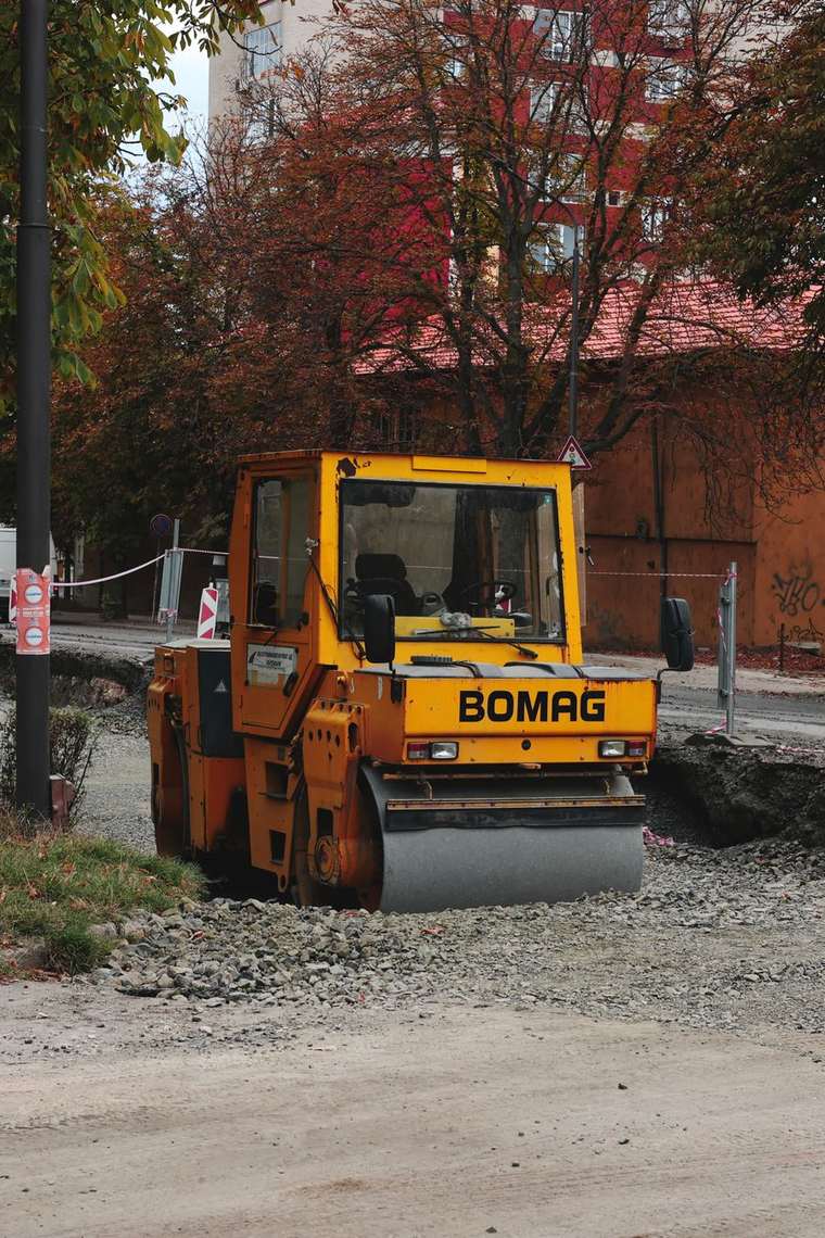 A small roller working beside autumn trees